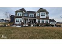 Charming two-story home with brick and siding exterior, covered porch, and manicured lawn at 12889 Girvan Way, Fishers, IN 46037