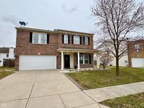 Two-story brick home with a well-manicured lawn, two-car garage, and a welcoming front porch at 1427 Broyles Ln, Indianapolis, IN 46231
