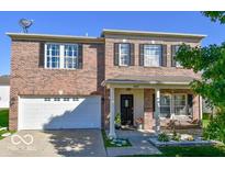 Charming two-story brick home featuring a covered porch with swing and attached two-car garage at 1427 Broyles Ln, Indianapolis, IN 46231