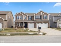 Traditional two-story home featuring a two-car garage, well-maintained lawn, and charming curb appeal at 1763 Wedgewood Pl, Avon, IN 46123