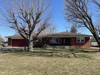 Charming brick home featuring an attached red garage and a well-maintained front lawn under a clear blue sky at 2130 Theobald St, Shelbyville, IN 46176