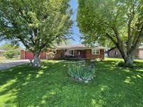 Charming brick home with well-maintained lawn, mature trees and flowerbeds enhancing the curb appeal at 2130 Theobald St, Shelbyville, IN 46176