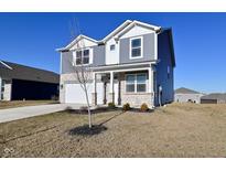 Well-maintained two-story home featuring a stone facade, gray siding, and a convenient two-car garage with a long drive at 2976 W Tapestry Dr, Monrovia, IN 46157