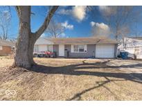Quaint single-story home featuring a front-facing single car garage and mature shade tree at 4212 Aspen Way, Indianapolis, IN 46226