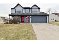 Two-story home featuring a red front door, an attached garage, and an American flag at 6619 Captiva Pass, Plainfield, IN 46168