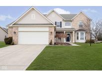Charming two-story home with a well-manicured lawn, attached two car garage and beautiful brick and vinyl siding at 8654 Arailia Dr, Plainfield, IN 46168