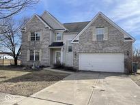 Two-story home with a front-facing garage and neutral colored brick facade at 9107 Tenor Way, Indianapolis, IN 46231