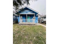 Charming blue home features a cozy front porch and well-maintained lawn at 945 N Ewing St, Indianapolis, IN 46201