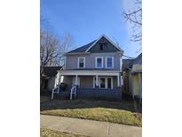Two-story home with covered porch and classic architectural details under a clear, blue sky at 123 S Butler Ave, Indianapolis, IN 46219