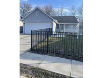 Charming single-story home with gray siding, a black metal fence and well-maintained lawn at 2027 E Werges Ave, Indianapolis, IN 46237