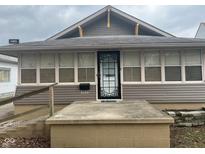 Charming home featuring a decorative front door, neutral siding, and a welcoming entrance platform at 2122 George St, Anderson, IN 46016