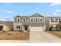 Charming two-story home with a two-car garage and neutral siding in a suburban neighborhood at 343 Traditions Pass, Greenwood, IN 46143