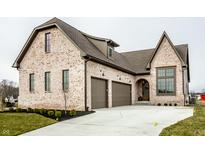 Elegant brick home with a two-car garage and manicured landscaping enhances curb appeal at 3588 Marketplace Ct, Zionsville, IN 46077