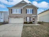 Charming two-story home featuring a brick and vinyl facade, attached garage, and well-maintained landscaping at 4140 Congaree Dr, Indianapolis, IN 46235