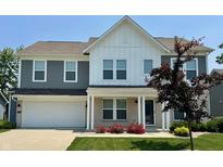 Charming two-story home features a brick and siding facade, well-manicured lawn, and an attached two-car garage at 5303 Rum Cherry Way, Indianapolis, IN 46237