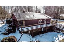 Charming home with stone accents and a metal roof, surrounded by snowy landscaping at 6910 S 175 W, Columbus, IN 47201