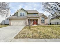 Inviting two-story home featuring a brick facade, two-car garage, and well-maintained lawn at 7044 Bel Moore Cir, Indianapolis, IN 46259