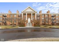 Beautiful brick condo building with columns, a front lawn and dark-paved entrance at 8751 Jaffa Court E Dr # 17, Indianapolis, IN 46260