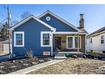 Charming blue two-story home with brick accents, landscaped yard, and inviting front porch at 105 N Irwin St, Indianapolis, IN 46219
