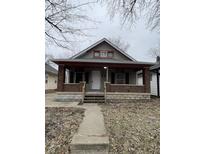 Charming home with brick-accented porch and stone foundation, offering classic curb appeal at 1207 N Kealing Ave, Indianapolis, IN 46201
