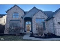 Charming brick home featuring a covered front entry, large windows, and professional landscaping at 13522 Spring Farms Dr, Carmel, IN 46032