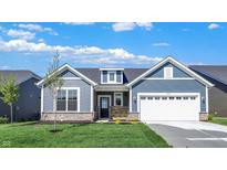 Charming single-story home boasts blue siding, stone accents, a two-car garage, and a well-manicured lawn at 19714 Highclere Ln, Sheridan, IN 46069