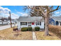 Charming home with tidy landscaping, front porch, and red front door at 2002 Fisher Ave, Indianapolis, IN 46224