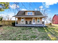 Charming home featuring a covered porch with rocking chairs and a well-maintained lawn and landscaping at 3011 S 550 W, Columbus, IN 47201