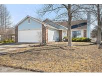 Charming home with a two-car garage, brick accents, light blue vinyl siding, and a well-manicured front yard at 3121 River Birch Dr, Indianapolis, IN 46235