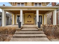 Inviting front porch with white pillars, dark planters, and a unique arch design on the facade at 3416 Guilford Ave, Indianapolis, IN 46205