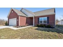 Charming brick home featuring an attached two-car garage and a well-maintained front lawn at 4729 Ozark Ln, Indianapolis, IN 46239