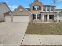 Charming two-story brick home featuring a well-manicured lawn and attached two-car garage at 5371 Hibiscus Dr, Plainfield, IN 46168