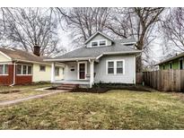 Charming gray home with a cozy front porch, mature trees, and well-maintained lawn at 5432 Winthrop Ave, Indianapolis, IN 46220