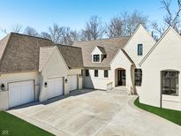 Stunning white brick home featuring a spacious driveway, attached garages, and manicured lawn at 580 Exmoor Dr, Carmel, IN 46032
