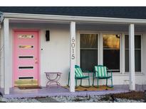 Charming front porch features a pink door and rocking chairs, offering a welcoming exterior at 6015 Pine Hill Dr, Indianapolis, IN 46235