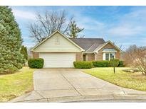 Charming brick home with a two-car garage and a well-manicured front lawn on a sunny day at 8221 Furlong Cir, Indianapolis, IN 46256