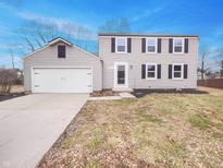 Charming two-story home features an attached garage, neutral siding, and well-maintained landscaping at 9318 Drawbridge Ct, Indianapolis, IN 46250