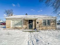 Charming brick single-story home with covered porch and snow-covered front yard at 1239 Brooks St, Indianapolis, IN 46202