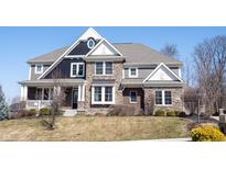 Charming two-story home featuring stone and siding exterior, a front porch, and manicured landscaping at 13702 Beam Ridge Dr, Fishers, IN 46055