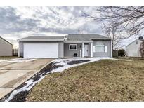 Charming home with a two-car garage, and well-manicured lawn on a cloudy day at 163 Country Wood Dr, Whiteland, IN 46184