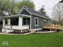Charming home showcasing a covered porch, wooden deck, and fresh landscaping on a neatly kept lawn at 1701 Barth Ave, Indianapolis, IN 46203