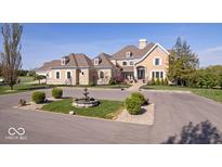 Elegant home with a circular driveway, mature landscaping, and a charming water fountain at 2766 S Honey Creek S Rd, Greenwood, IN 46143