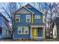 Charming two-story home featuring blue siding, bright yellow trim, and inviting front porch at 3224 N Capitol Nw Ave, Indianapolis, IN 46208