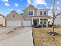 Charming two-story brick and shake home with a three-car garage and a well-manicured front lawn at 6922 Kara Ln, Brownsburg, IN 46112