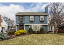 View of blue two-story home with shutters, mature trees, and green lawn at 722 Northview Ave, Indianapolis, IN 46220
