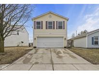 Charming two-story home with a two car garage, yellow siding, and purple window shutters at 10613 Glenayr Dr, Camby, IN 46113