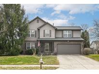 Two-story home featuring a two-car garage and a well-manicured front yard under a partly cloudy sky at 10867 Pine Bluff Dr, Fishers, IN 46037