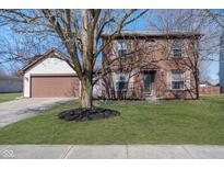 Two-story home featuring a brown two-car garage, brick facade and a well-manicured front lawn at 11138 Baywood Ln, Indianapolis, IN 46236