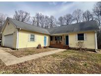 Charming ranch-style home with light yellow siding, a welcoming front porch, and a well-manicured lawn at 1195 Hinson Rd, Martinsville, IN 46151