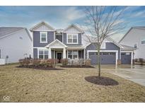 Charming two-story home featuring a three car garage, neutral siding, and well-maintained lawn at 12504 Castle Pine Dr, Noblesville, IN 46060